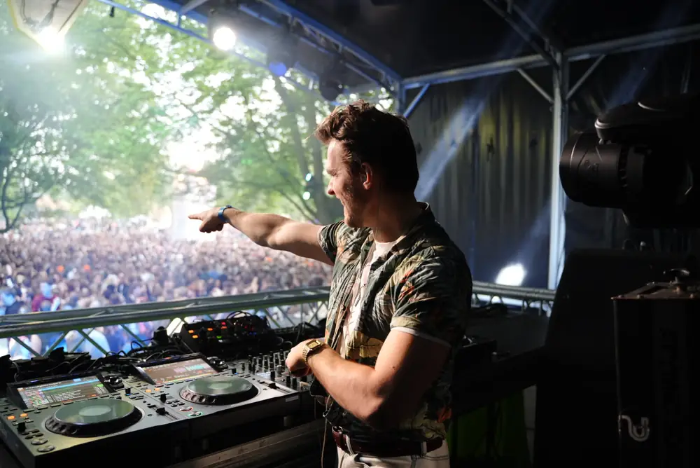 Laurentius on the microphone behind the DJ booth during a live set